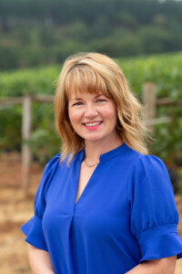 valls_Knudsen_1088_headshots_WEB-patty-noPIN Smiling middle-age woman with cropped, wavy light brunette hair.